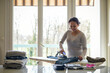 © AUFORT Jérome - mixed race woman ironing at home