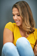 Poster - Not a care in the world. Studio shot of an attractive young woman against a grey background.