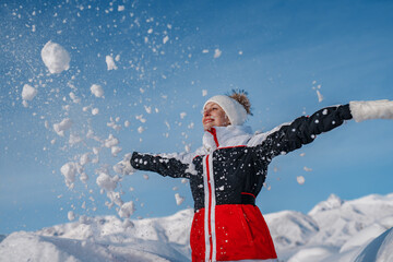 Poster - Young happy woman throw snow on winter mountains background