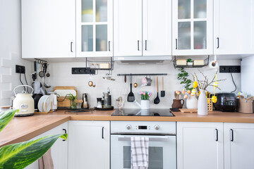 Interior of kitchen and details of decor of utensils with Easter decoration of colorful eggs in a loft style. Festive interior of a country house