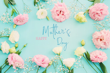 Wall Mural - mother's day concept with pink flowers over pastel blue background