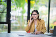 © Tj - Happy businesswoman talking on mobile phone while analyzing weekly schedule in the office.