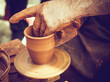 © RooM The Agency - Close-up of a potter moulding clay on a potter's wheel