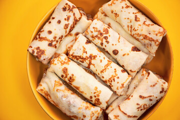 homemade pancakes with meat filling in a plate on a bright background