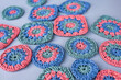 Closeup of multicolored crochet circles and squares on grey back