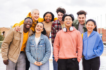 portrait of big group of teenage multiracial young friends smiling and looking at camera. front view