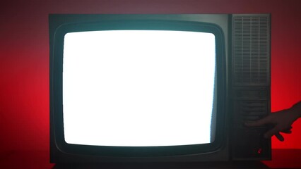 Retro TV on dark red illuminated background, antique television with blinking display screen, bad signal and horizontal stripes, person hand switching on and off different buttons on control panel