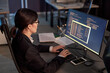 © Seventyfour - High angle portrait of female software developer writing code while using computer at workplace in office
