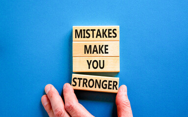 Wall Mural - Mistake make stronger symbol. Concept words Mistakes make you stronger on wooden blocks. Beautiful blue table blue background. Businessman hand. Business mistake make stronger concept. Copy space.