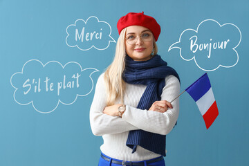 Wall Mural - Beautiful woman with flag of France on light blue background. International French Language Day