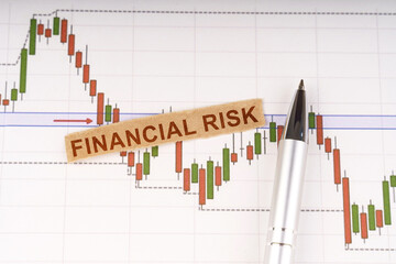 Wall Mural - On the chart of business quotes lies a pen and torn paper with the inscription - financial risk