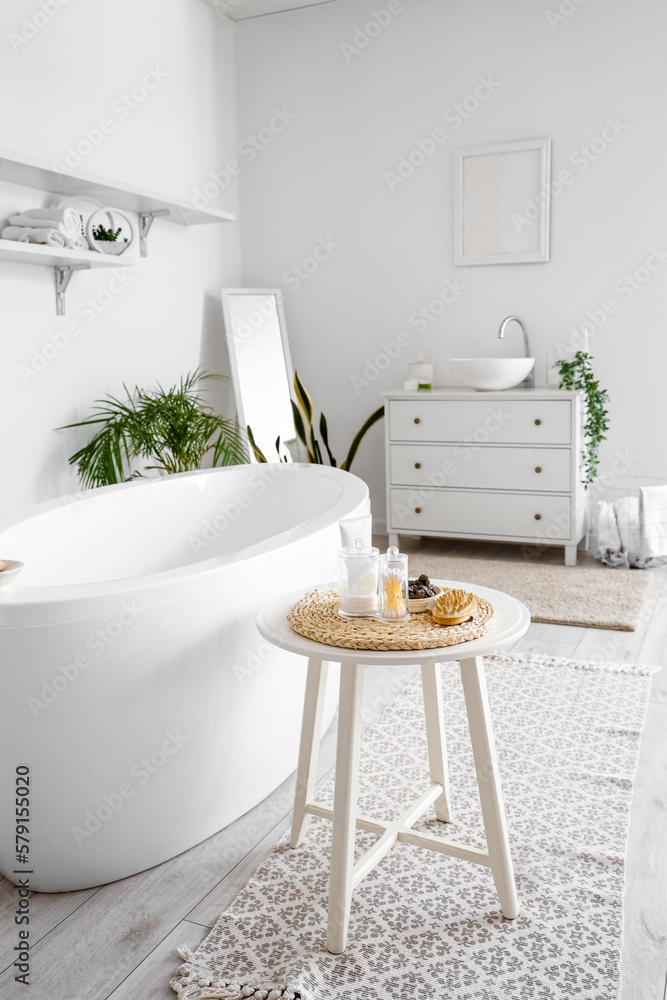 Interior of bathroom with bathtub, table and sink