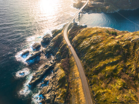 aerial view of bridge, car, sea with waves and mountains at sunset in lofoten islands, norway. lands