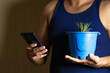 © Narayan - man holding a potted plant for decoration, houseplant concept