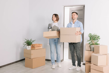 Canvas Print - Happy couple with moving boxes entering in new apartment