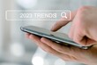 © BillionPhotos.com - Businessman with smartphone and 2023 trends text
