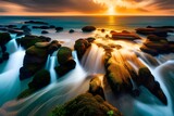 Fototapeta  - Zachód słońca nad wodą, kamienisty brzeg ze spiętrzoną wodą, skały i duże kamienie na brzegu, wysoki stan wody przelewającej się przez brzeg.