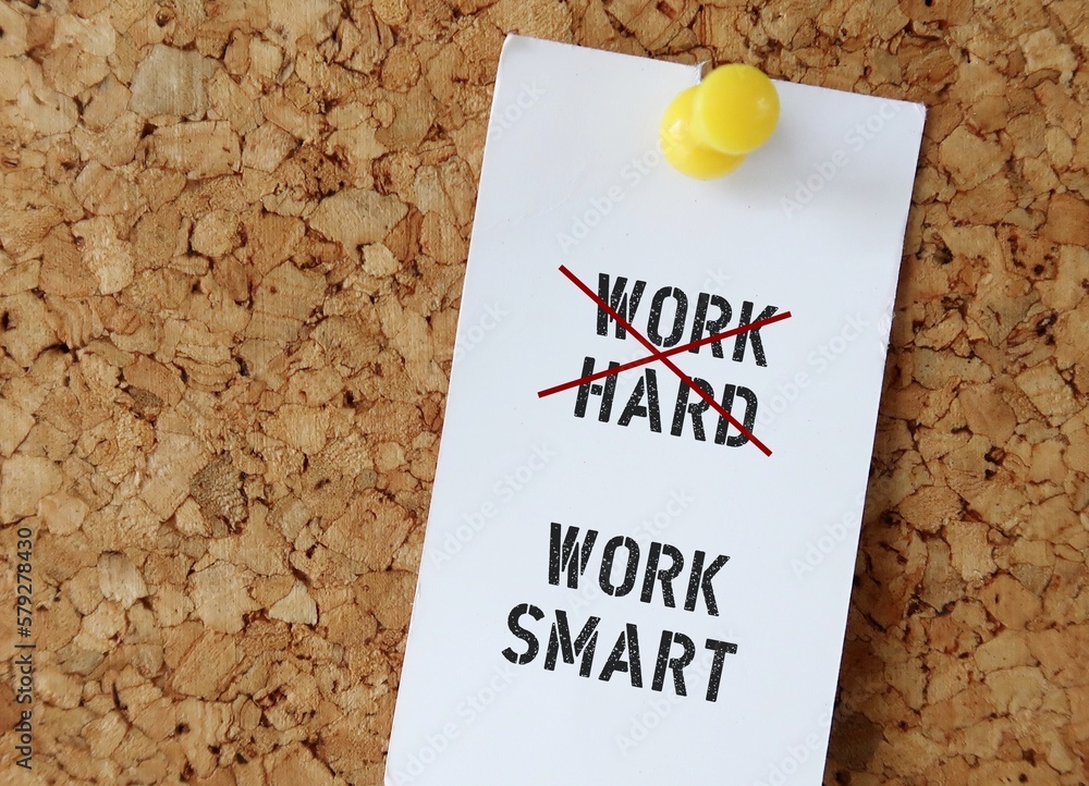 Pinned note on board with text WORK HARD (red crossing) WORK SMART , means smart worker complete work within timelines using shortcut ,proper planning , prior research , instead of working long hours