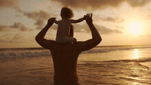 Family Idyll - Father Playing With His Little Son On Beach During Sunset, Carrying Him On His Shoulders, Enjoying Their Vacation Together - Recreational Pursuit, Dream Concept 