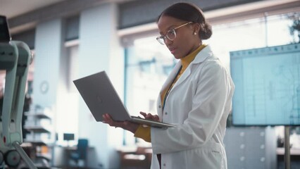 Poster - Young Black Female Engineer Testing Industrial Programmable Robot Animal in a Factory Development Workshop. Professional Researcher in a Lab Coat Developing AI Canine Prototype, Using Laptop