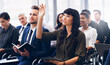 © Arcurs Co-op/peopleimages.com - Can I ask a question. Cropped shot of an attractive young businesswoman sitting with her diverse colleagues and raising her hand while in the office.