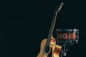 Acoustic guitar and snare drum on a black background isolated.