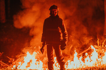 Firefighter at job. Firefighter in dangerous forest areas surrounded by strong fire. Concept of the work of the fire service