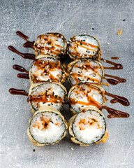 Wall Mural - Set of sushi rolls with smoked eel, cream cheese, unagi sauce, sesame seeds, breadcrumbs, tempura, rice, nori.