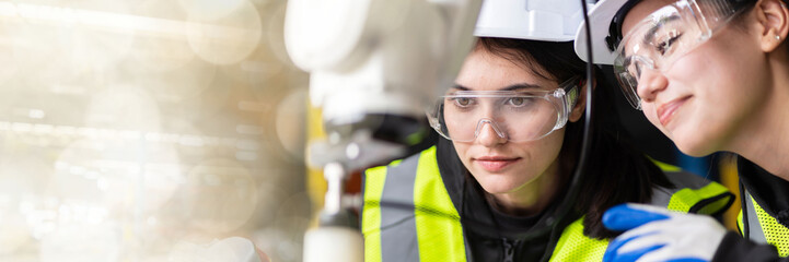 web banner A team of female engineers meeting to inspect computer-controlled steel welding robots. Plan for rehearsals and installation for use.