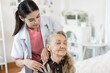 © chachamp - Doctor woman take care smiling older caucasian woman of shoulder massage home