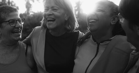 Wall Mural - Happy multiracial senior women having fun together after sport workout at city park - Black and white editing
