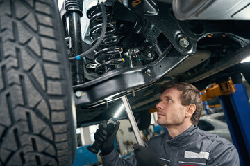 Wall Mural - Professional male checking wheel in the workshop