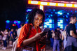 © bernardbodo - Young girl with smartphone at music festival.