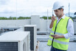 © Shisu_ka - Asian maintenance engineer works on the roof of factory. contractor inspect compressor system and plans installation of air condition systems in construction. technology, online checking, mobile app