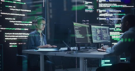 Fototapete - Young Man and Woman Working on Desktop Computers, Surrounded by Big Screens Displaying Code Lines. Professional Computer Engineers Developping System Control and Monitoring Telecommunications