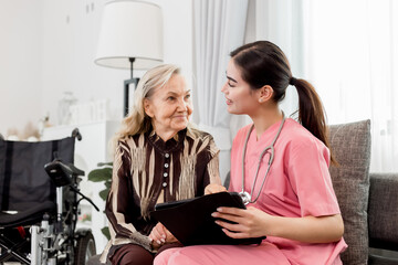 Wall Mural - Caucasian caregiver lady consulting with elderly woman patient. Happy old mature man sitting on couch sofa talking to nurse at nursing home. Healthcare support with senior woman for medical help.