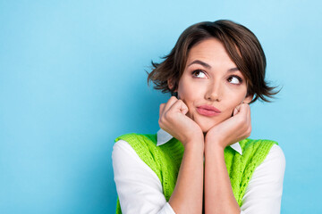 Poster - Portrait of cute minded girl arms touch cheekbones look interested empty space isolated on blue color background