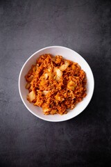 Poster - Vertical top view of a Korean kimchi in a white bowl on a gray table