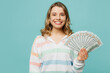 © ViDi Studio - Young smiling fun blonde woman wear striped hoody hold in hand fan of cash money in dollar banknotes look camera isolated on plain pastel light blue cyan background studio portrait. Lifestyle concept.
