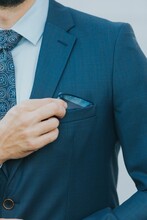Vertical Shot Of A Man In A Blue Business Suit Fixing His Pocket Handkerchief