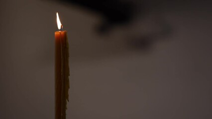 Wall Mural - Closeup shot of a lighting candle on a blurred background