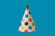 © Nikolay - Bright and colorful birthday cap isolated on a blue background.