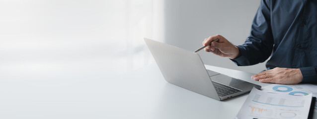 Wall Mural - Business man pointing to a pie chart document showing company financial information, He sits in her private office, a document showing company financial information in chart form. Financial concepts