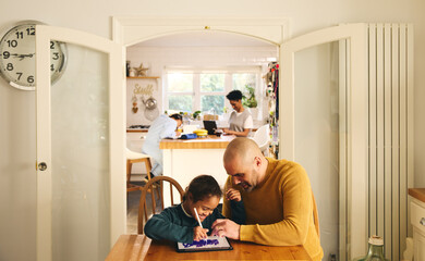 Multiracial family at home with father and son with Down syndrome using digital tablet