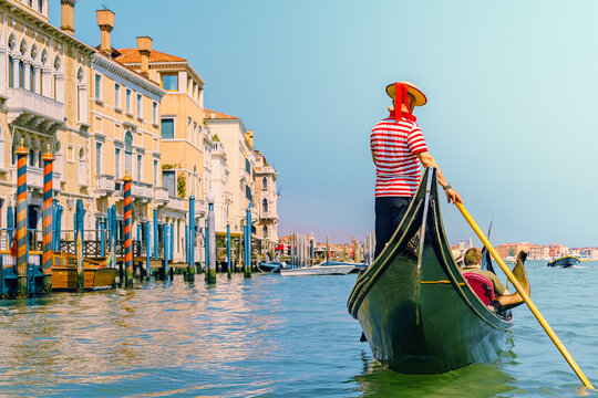 a venetian gondolier leisurely rows past the historic buildings in the rio grande.
