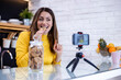 © ivanko80 - Portrait of smiling young influencer holding homemade cookies while recording video