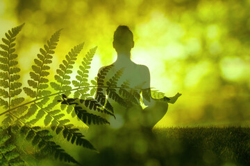 Young female meditating in a green forest nature setting. Find your inner peace 