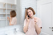 © Vitaliy - Young excited woman standing in the bathroom, talking on mobile phone and telling to her husband about positive result of pregnancy test