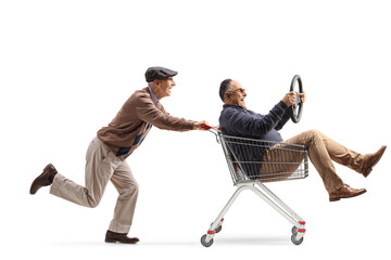 Canvas Print - Elderly man pushing a friend inside a shopping cart holding a steering wheel