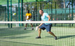 © JackF - Man in t-shirt playing padel tennis on court. Racket sport training outdoors.